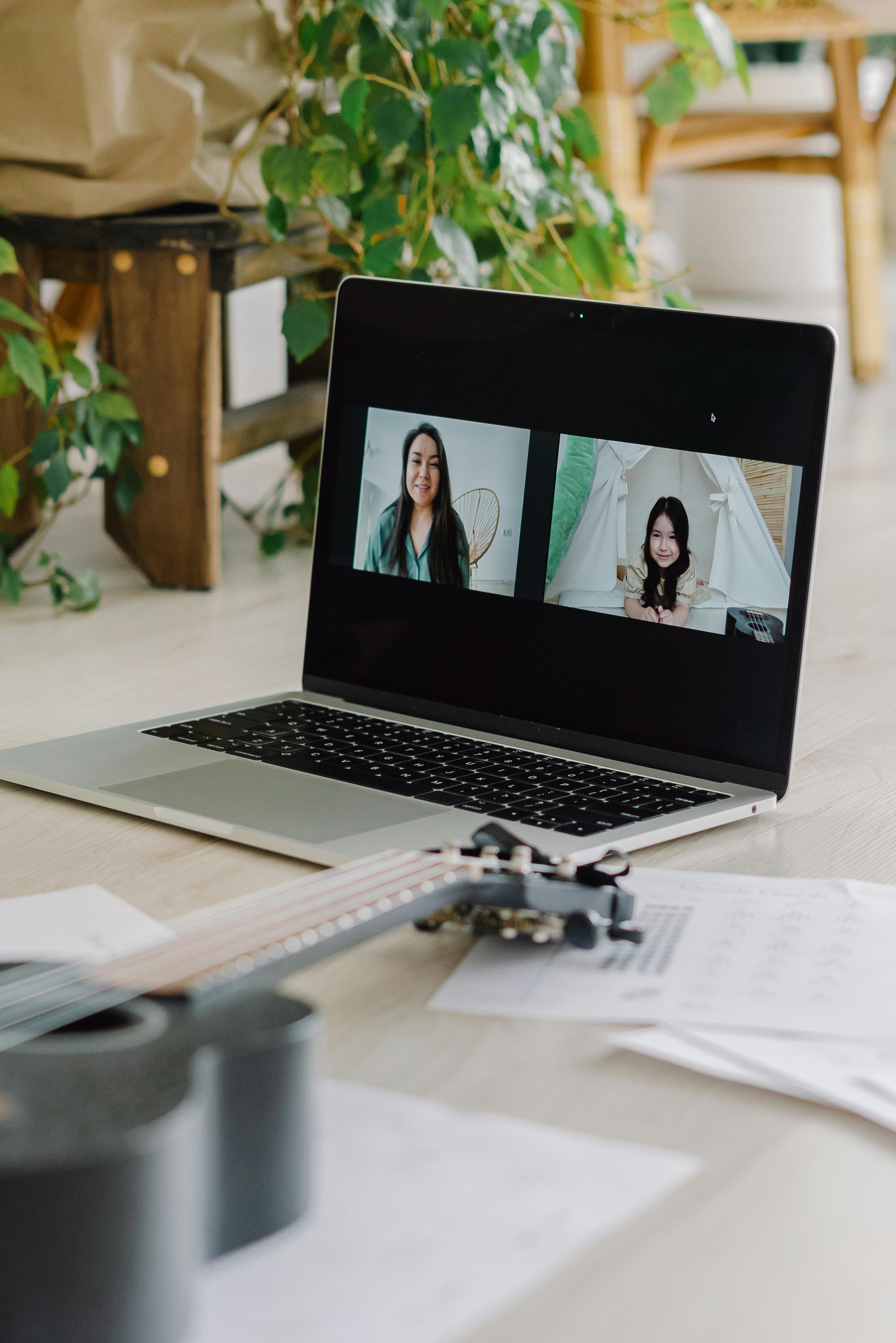 Laptop showing a Zoom voice lesson with ukulele and sheet music